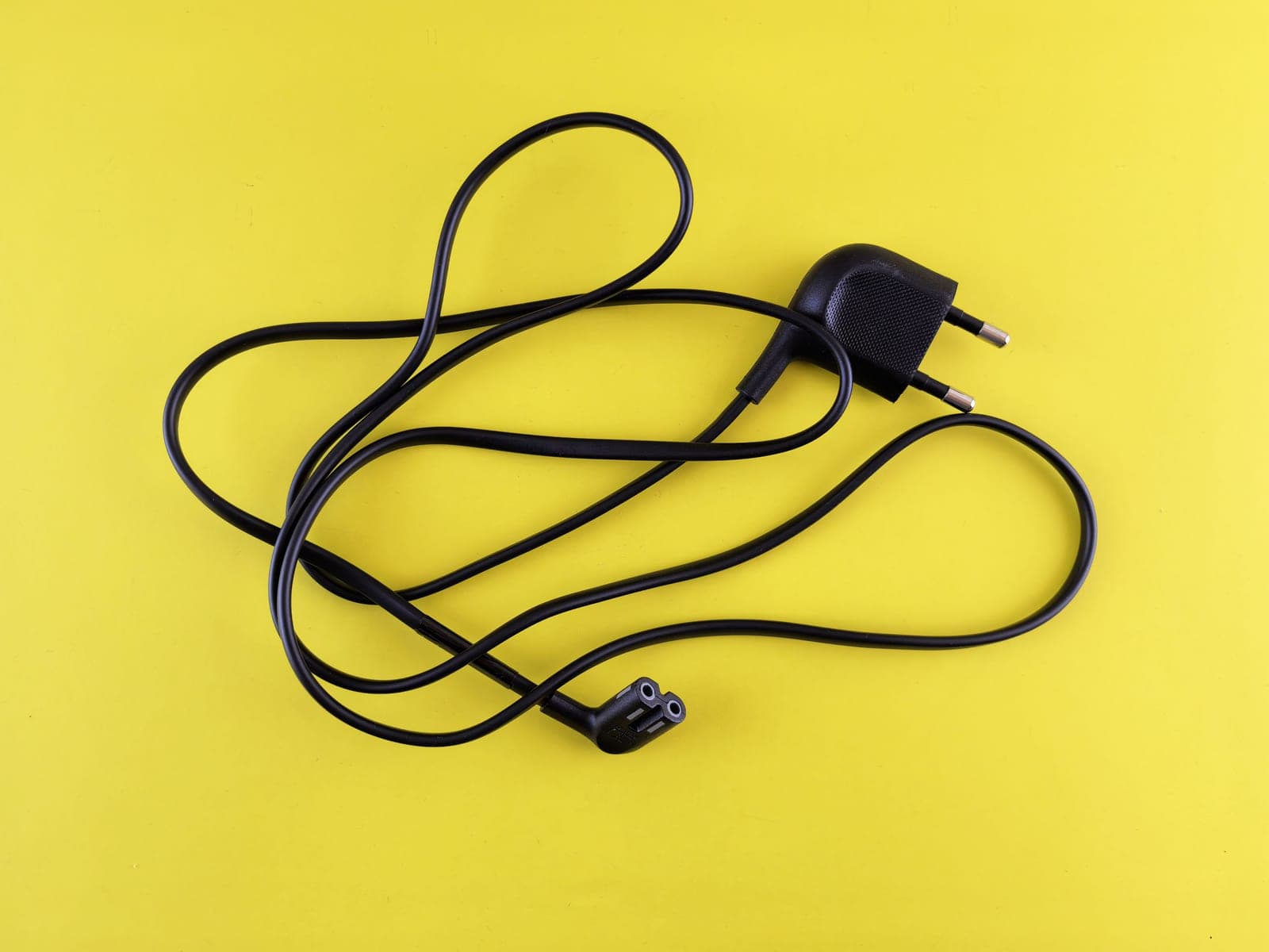 A portable electric vehicle charging cable coiled and hung on a hook